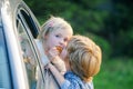 Little boy gives kiss for cute girl. Bye bye. Funny little couple saying goodbye before car travel. Farewell child