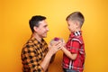 Little boy giving present to his dad on color background Royalty Free Stock Photo