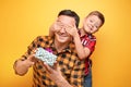 Little boy giving present to his dad on color background Royalty Free Stock Photo