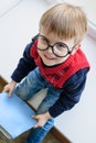 Little boy in glasses with book in library on window Royalty Free Stock Photo