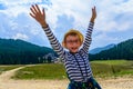 Little boy in glasses and a hat in a background of mountains and