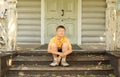 Little boy in glasses seat on doorstep Royalty Free Stock Photo
