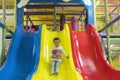 Little boy is going down a slide at the playground. He is laughing and having fun on the jungle gym. Boy riding from childrens Royalty Free Stock Photo