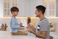 Little boy greeting his dad with Father`s Day in kitchen Royalty Free Stock Photo