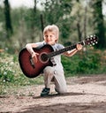 Little boy with guitar on the Boulevard in the Park Royalty Free Stock Photo