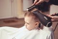 Little boy at the hairdresser. Child is scared of haircuts. Hair