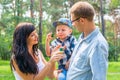 A little boy in the hands of the dad and blow soap bubbles. Mom Royalty Free Stock Photo