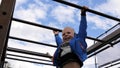 Little boy hanging on monkey bars Royalty Free Stock Photo