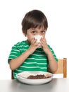 Little boy has his breakfast at the table