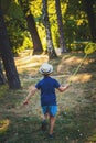 Little boy with hat and butterfly net run in wood or park back v Royalty Free Stock Photo