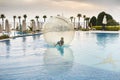 Little boy have fun inside big plastic balloon on the water of swimming pool on the summer resort. Kid inside big inflatable Royalty Free Stock Photo