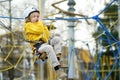 Little boy having fun in Adventure Park for children amoung ropes, stairs, bridges. Outdoor climbing adventure playground in