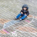 Little boy having fun with airplane picture drawing with chalk Royalty Free Stock Photo