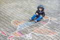 Little boy having fun with airplane picture drawing with chalk Royalty Free Stock Photo