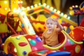 Little boy having fun on attraction in public park. Child riding on a merry go round at summer evening. Attraction, planes, cars, Royalty Free Stock Photo