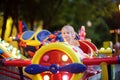 Little boy having fun on attraction in public park. Child riding on a merry go round at summer evening. Attraction, planes, cars, Royalty Free Stock Photo