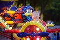 Little boy having fun on attraction in public park. Child riding on a merry go round at summer evening. Attraction, planes, cars, Royalty Free Stock Photo