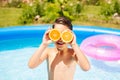 Little boy having fun with oranges in the pool Royalty Free Stock Photo