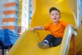 Little boy having fun on a playground outdoors in summer. Playful toddler on a slide. Royalty Free Stock Photo