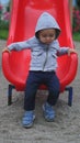 Little boy having fun on a playground outdoors in summer. Toddler on a slide Royalty Free Stock Photo