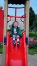 Little boy having fun on a playground outdoors in summer. Toddler on a slide Royalty Free Stock Photo