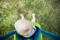 A little boy having fun playing on a swing under a tree in a garden Royalty Free Stock Photo