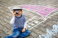 Little boy having fun with ship picture drawing with chalk Royalty Free Stock Photo