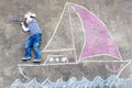 Little boy having fun with ship picture drawing with chalk Royalty Free Stock Photo