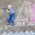 Little boy having fun with ship picture drawing with chalk Royalty Free Stock Photo