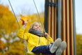 Little boy having fun on a swing on the playground in public park on autumn day. Happy child enjoy swinging. Active outdoors Royalty Free Stock Photo