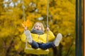 Little boy having fun on a swing on the playground in public park on autumn day. Happy child enjoy swinging. Active outdoors Royalty Free Stock Photo