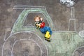 Little boy having fun with tractor picture drawing with chalk Royalty Free Stock Photo