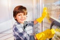 Little boy having fun washing windows at home Royalty Free Stock Photo