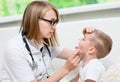 Little boy having his throat examined by health professional