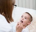 Little boy having his throat examined by health professional