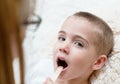 Little boy having his throat examined by health professional