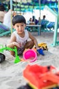Little boy having lots of fun with his toys playing in the sand outdoors. Concentrated toddler playing with his toy. child plays w Royalty Free Stock Photo