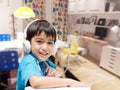 Little boy with headset doing home work in the room