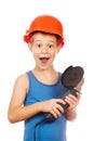 Little boy in a helmet with electric hammer