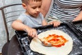 Little boy helping mom make pizza at home Royalty Free Stock Photo