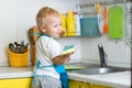 Little boy helping mother washing dishes in the kitchen Royalty Free Stock Photo