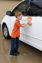 Little boy helping wash the family car