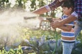 Boy helping watering vegetables in the garden Royalty Free Stock Photo