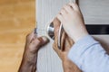 Little boy helps his fother repair the doorknob. closeup of man`s and child hands installing new door locker Royalty Free Stock Photo