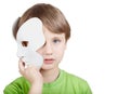 Little boy hides half of face behind mask Royalty Free Stock Photo