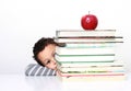 Little boy hiding behind a big stack of books Royalty Free Stock Photo