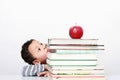 Little boy hiding behind a big stack of books Royalty Free Stock Photo