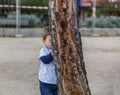 A little boy is hiding behind a tree Royalty Free Stock Photo