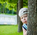 Little boy hiding behind tree Royalty Free Stock Photo
