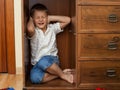 Little boy hiding in a cupboard and crying Royalty Free Stock Photo